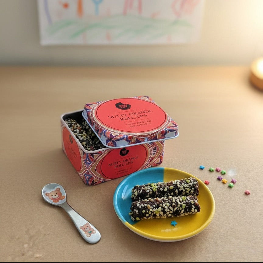 Snack container with two bars on a plate, spoon, and colorful background